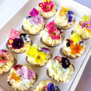 cupcakes decorated with colourful edible flowers