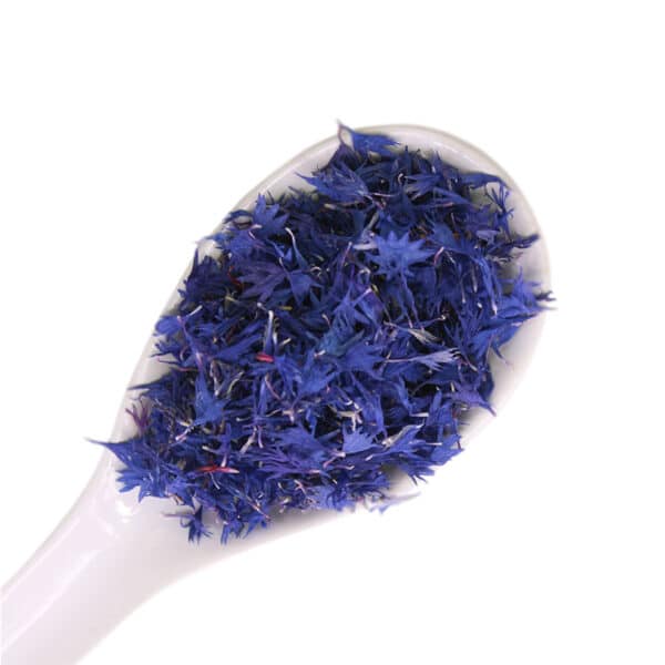 dried cornflowers edible flowers on a white spoon