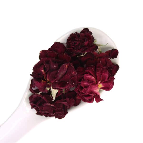 dried roses edible flowers on a white spoon