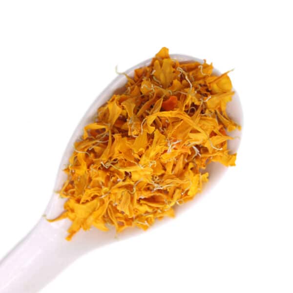 dried tagetes edible flowers on a white spoon