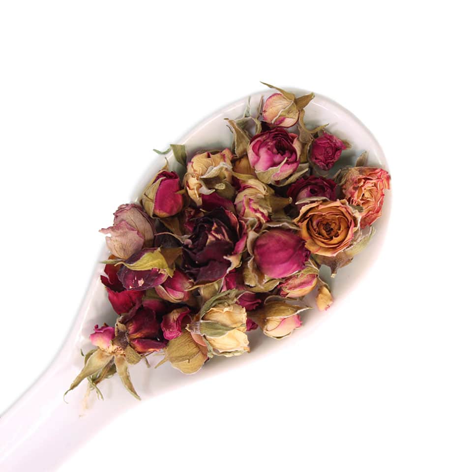 dried rose buds edible flowers on a white spoon