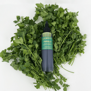 Parsley herb oil laying on fresh flat leaf Parsley