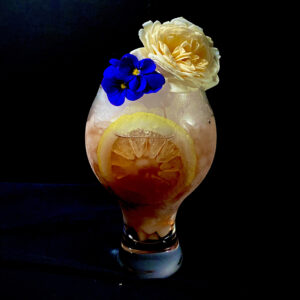 Lizzy Swizzle Cocktail topped with Edible Flowers